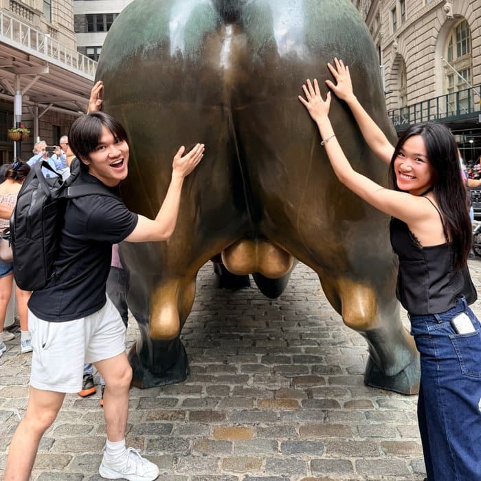 Mandy and a friend posing with the Charging Bull on Wall Street