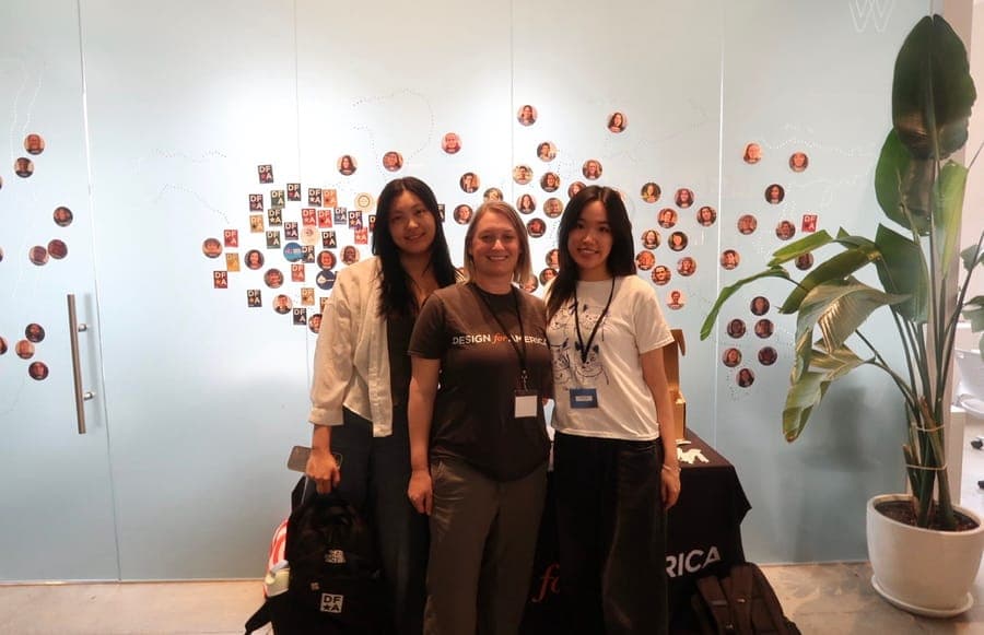 Mandy and two others in front of the Design for America member wall